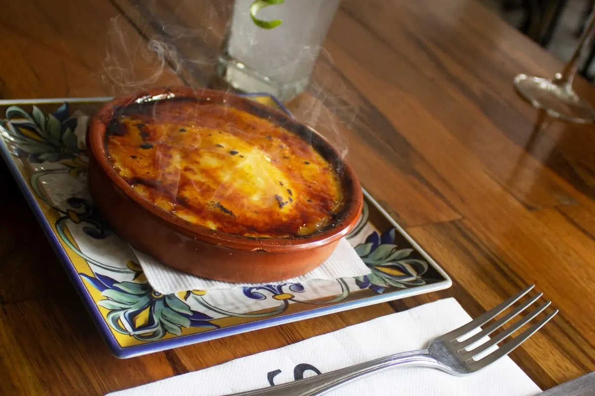 Postre en cazuela de barro acompañado de un cóctel